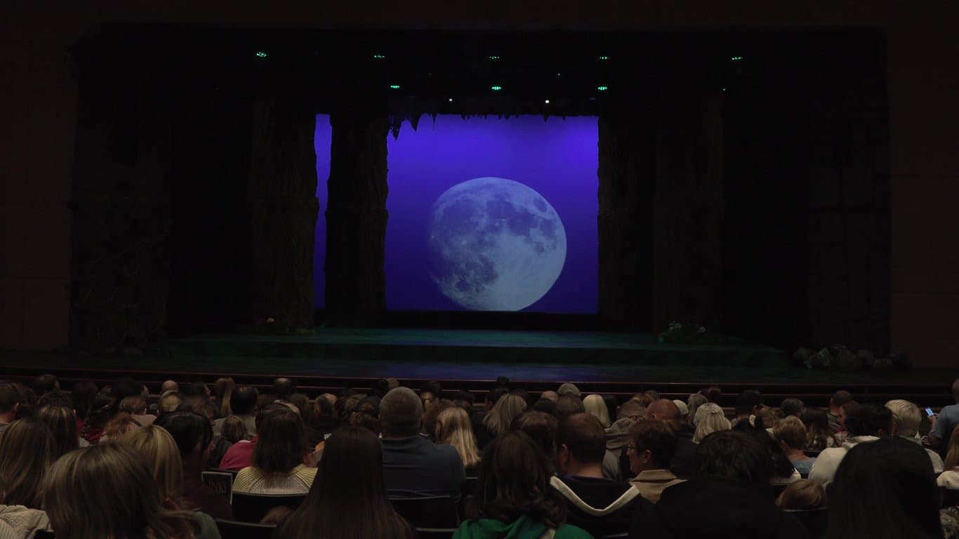Audience waiting in a community theatre auditorium